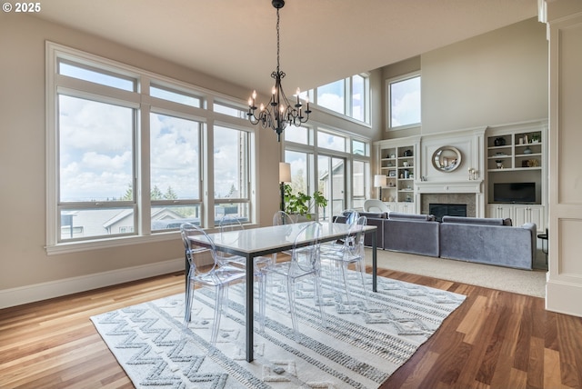 2640 NW Birkendene St, Portland, OR 97229 - dining area with healthy amount of natural light, a chandelier, a fireplace, baseboards, and a high ceiling