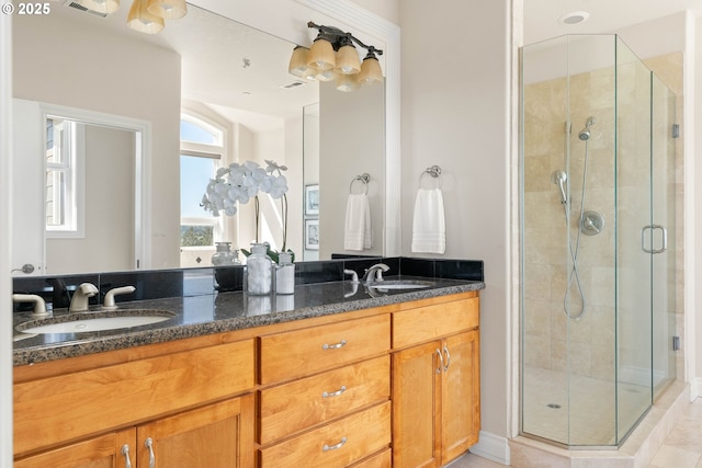 full bathroom featuring a sink, double vanity, and a stall shower