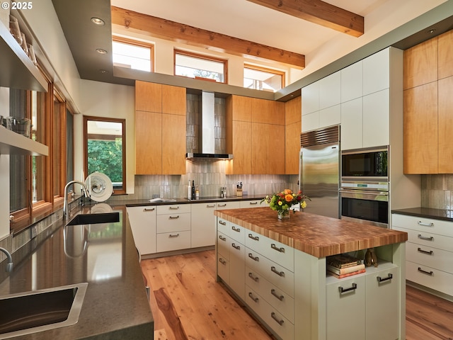 448 NW Skyline Blvd, Portland, OR 97229 - kitchen featuring black appliances, a sink, wall chimney exhaust hood, backsplash, and butcher block counters