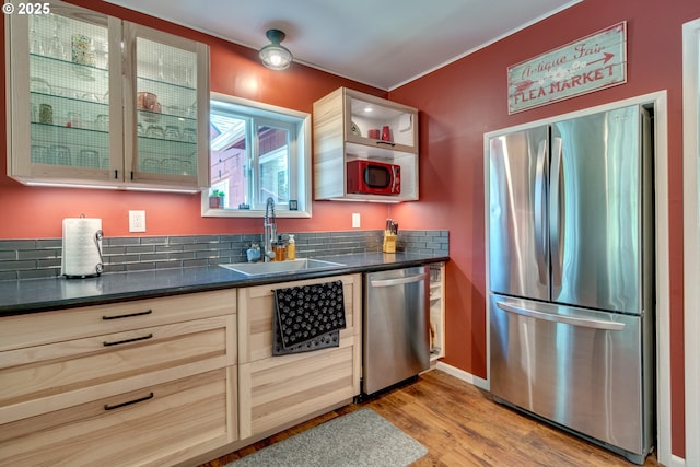 kitchen with a sink, dark countertops, glass insert cabinets, and stainless steel appliances