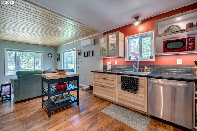 kitchen featuring an AC wall unit, a sink, dark countertops, dark wood-style floors, and dishwasher