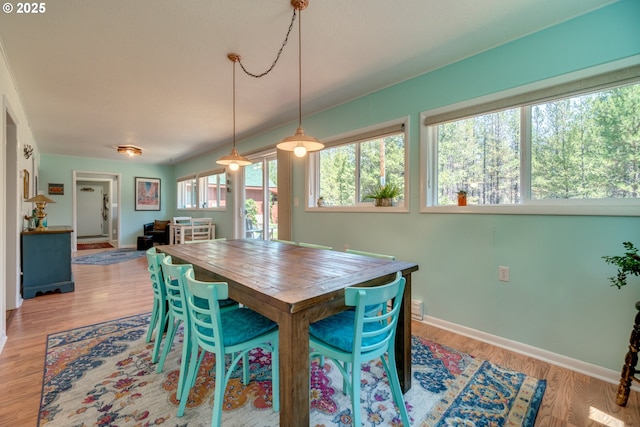 dining space featuring light wood-style flooring and baseboards