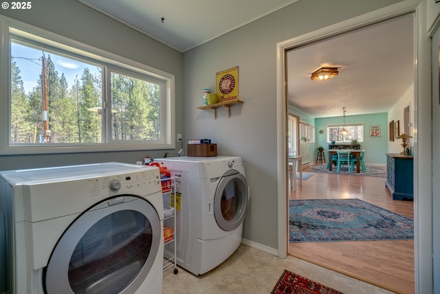 laundry area with washer and clothes dryer, laundry area, light wood-style flooring, and baseboards