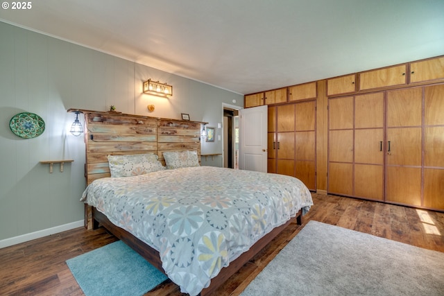 bedroom with baseboards and wood finished floors