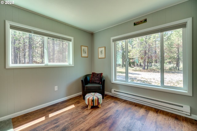 unfurnished room with ornamental molding, wood finished floors, baseboards, and a baseboard radiator