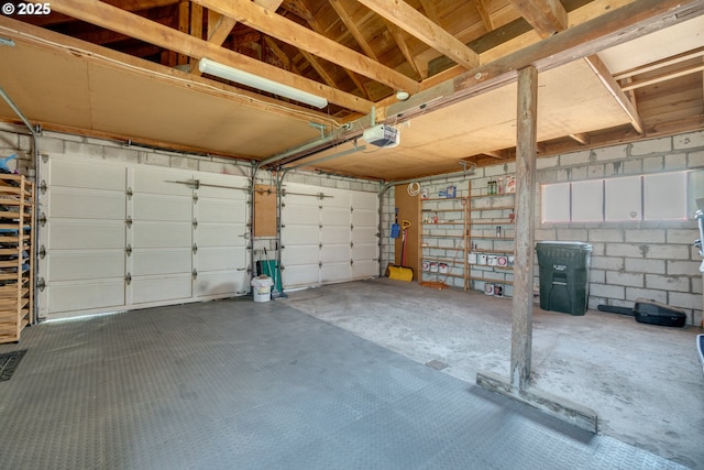 garage with concrete block wall and a garage door opener