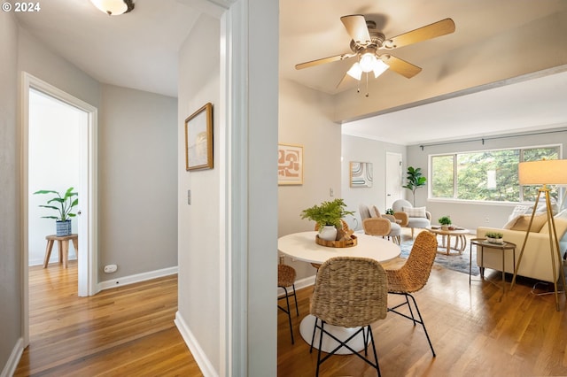 dining space with hardwood / wood-style floors and ceiling fan