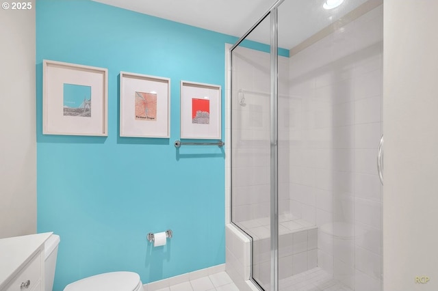 bathroom featuring tile patterned floors, a stall shower, toilet, and vanity