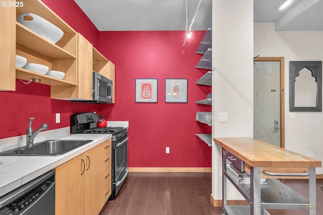 kitchen featuring dark wood-style floors, baseboards, open shelves, a sink, and appliances with stainless steel finishes