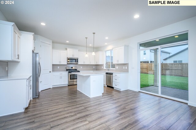 18615 NE 41st Pl Lot 288, Vancouver, WA 98686 - kitchen with wood finished floors, stainless steel appliances, light countertops, a kitchen island, and white cabinetry