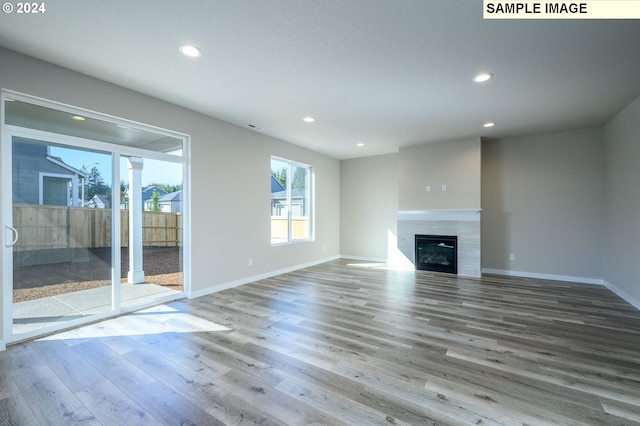 18615 NE 41st Pl Lot 288, Vancouver, WA 98686 - unfurnished living room featuring recessed lighting, a tiled fireplace, wood finished floors, and baseboards