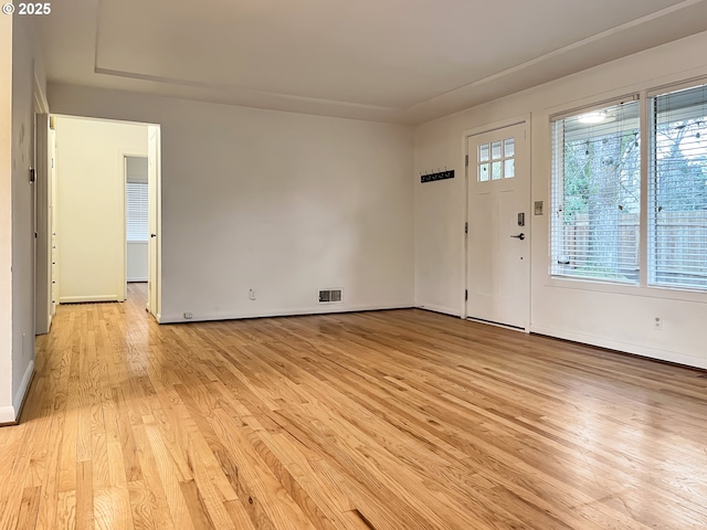 foyer with visible vents, baseboards, and light wood-style flooring