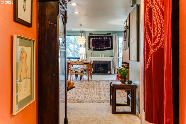 hallway featuring light carpet and a chandelier