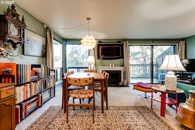 dining space featuring an inviting chandelier, a healthy amount of sunlight, and light carpet