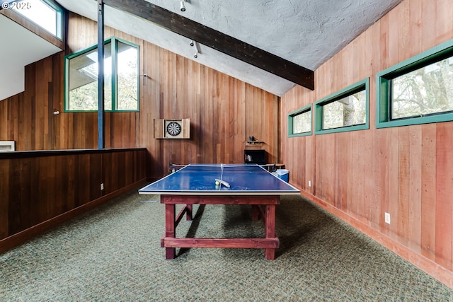 playroom with vaulted ceiling with beams, wood walls, a healthy amount of sunlight, and carpet