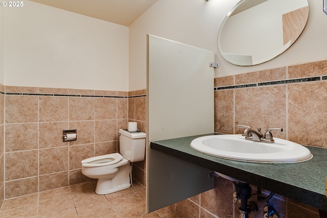 bathroom featuring tile walls, sink, tile patterned flooring, and toilet