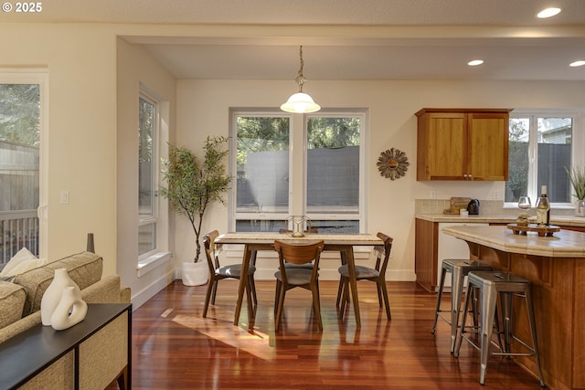 dining space featuring recessed lighting, dark wood finished floors, baseboards, and plenty of natural light