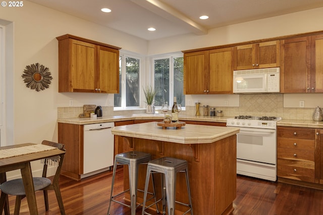 kitchen featuring brown cabinetry, white appliances, tile counters, and dark wood-type flooring