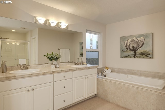full bath featuring double vanity, a bath, a stall shower, and a sink
