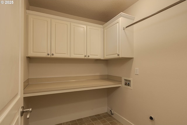 laundry room with hookup for a washing machine, dark tile patterned flooring, cabinet space, baseboards, and a textured ceiling