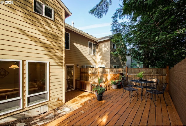wooden terrace featuring fence and outdoor dining space