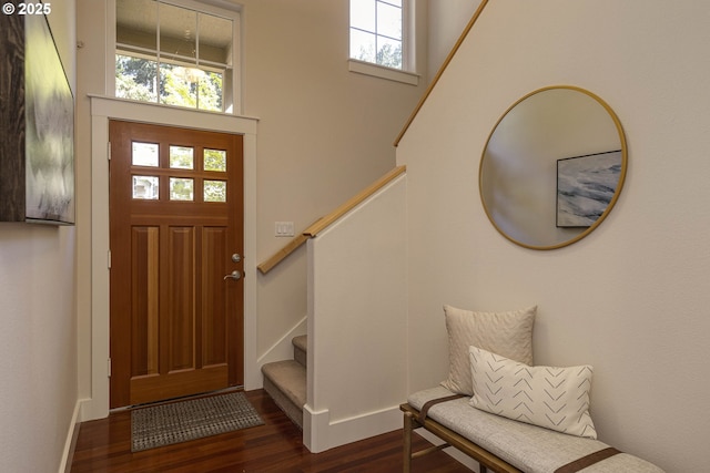 entrance foyer with baseboards, stairs, dark wood-style flooring, and a high ceiling
