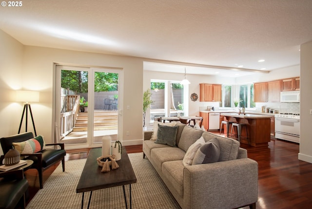 living room with a healthy amount of sunlight, recessed lighting, and dark wood finished floors
