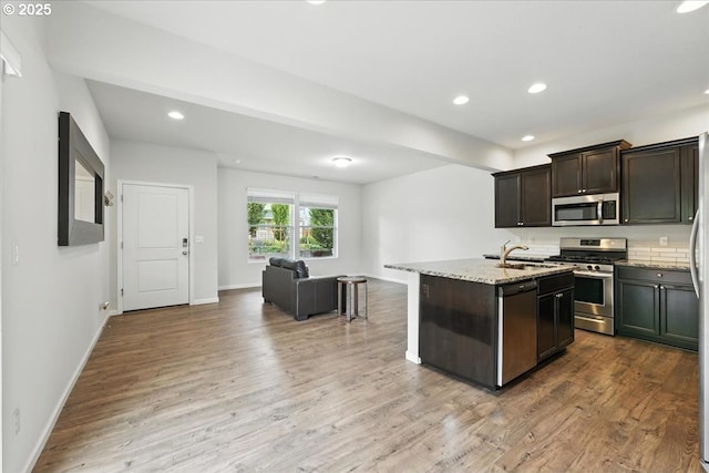 2103 SE 18th Aly, Gresham, OR 97080 - kitchen featuring appliances with stainless steel finishes, open floor plan, wood finished floors, recessed lighting, and light stone counters