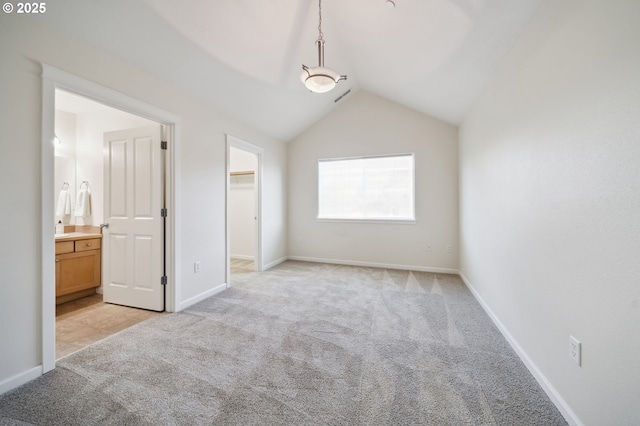 7612 NE 34th Ave Unit A8, Vancouver, WA 98665 - unfurnished bedroom featuring connected bathroom, a spacious closet, baseboards, light colored carpet, and lofted ceiling