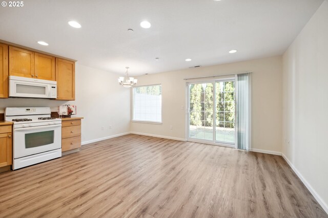 7612 NE 34th Ave Unit A8, Vancouver, WA 98665 - kitchen featuring open shelves, a sink, white appliances, light wood-type flooring, and baseboards
