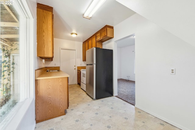 kitchen featuring stainless steel fridge, sink, and stove