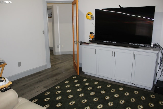 living room featuring dark wood-type flooring and baseboards