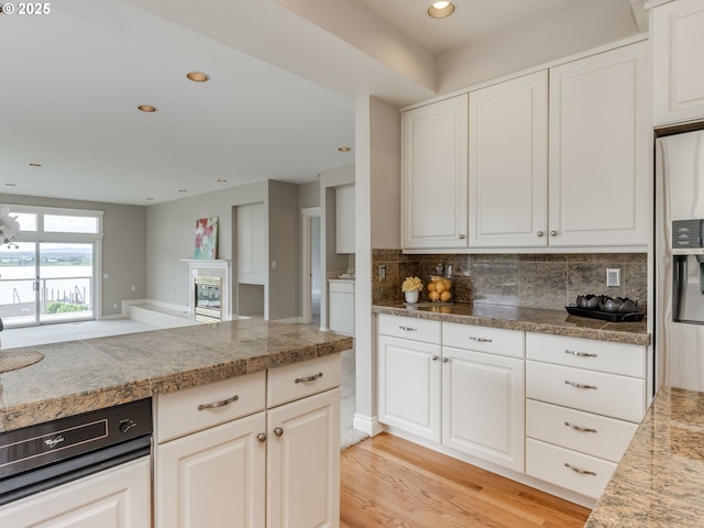 6903 SE Riverside Dr Unit 20, Vancouver, WA 98664 - kitchen with tile countertops, refrigerator with ice dispenser, tasteful backsplash, white cabinets, and recessed lighting