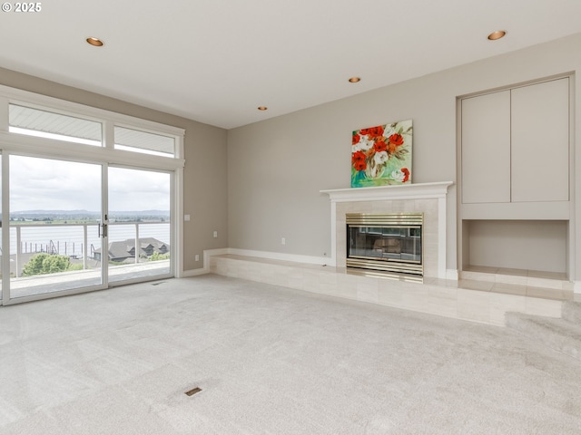 6903 SE Riverside Dr Unit 20, Vancouver, WA 98664 - unfurnished living room with light carpet, a tile fireplace, recessed lighting, a water view, and baseboards