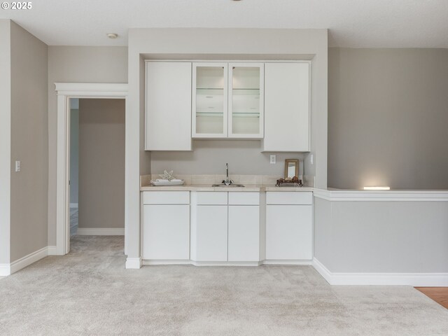 6903 SE Riverside Dr Unit 20, Vancouver, WA 98664 - kitchen with light countertops, a sink, light carpet, white cabinets, and glass insert cabinets
