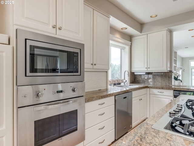 6903 SE Riverside Dr Unit 20, Vancouver, WA 98664 - kitchen with stainless steel appliances, a sink, white cabinetry, tasteful backsplash, and recessed lighting
