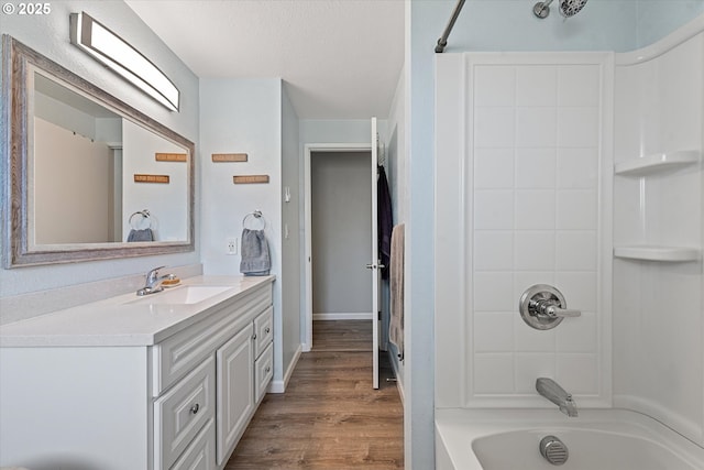 1220 Baker St, Baker City, OR 97814 - bathroom with vanity, tub / shower combination, wood finished floors, a textured ceiling, and baseboards
