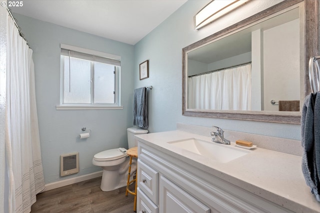 1220 Baker St, Baker City, OR 97814 - bathroom with heating unit, vanity, toilet, wood finished floors, and baseboards
