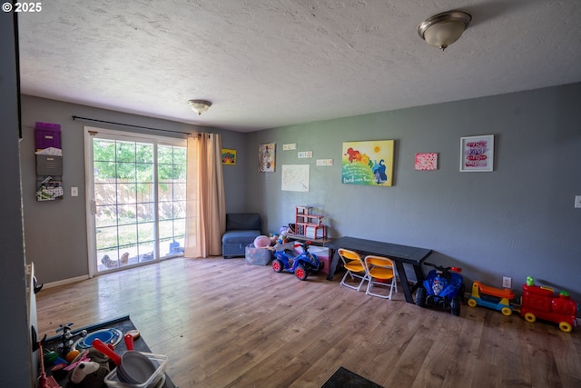 rec room with wood-type flooring and a textured ceiling