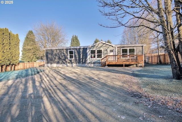 rear view of property featuring a wooden deck