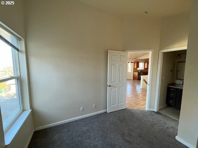 spare room with dark carpet