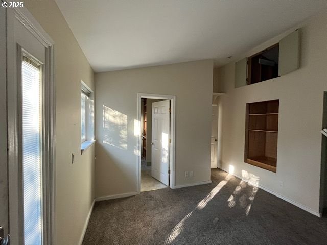 spare room featuring carpet floors and vaulted ceiling