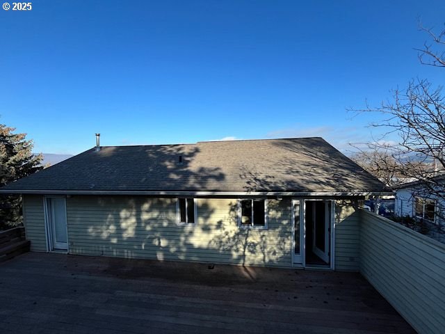 rear view of property featuring a wooden deck