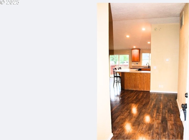 hallway with recessed lighting, dark wood-style flooring, a sink, and baseboards
