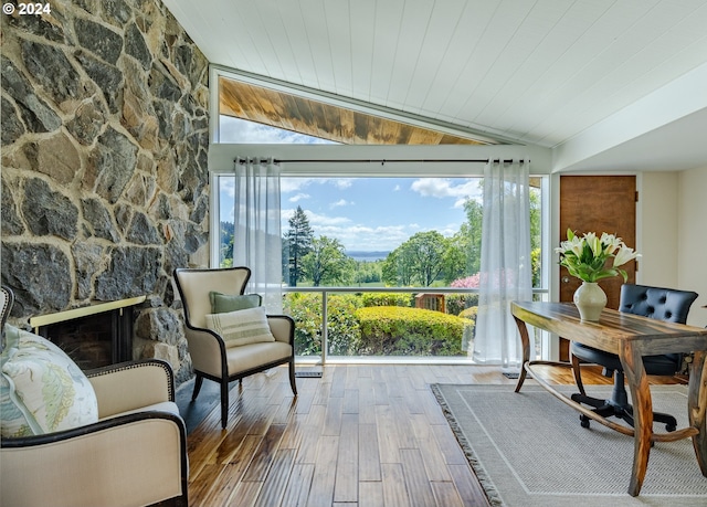 living area with a fireplace, hardwood / wood-style floors, wooden ceiling, and vaulted ceiling