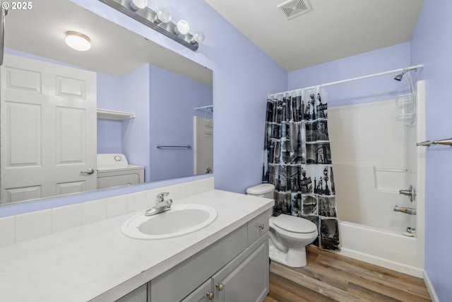 full bathroom featuring washer / dryer, shower / bath combo, visible vents, toilet, and wood finished floors