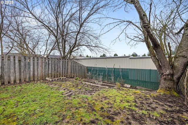 view of yard featuring fence and an outbuilding