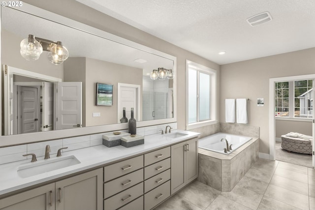 17641 NW Layla Dr, Portland, OR 97229 - full bath featuring double vanity, plenty of natural light, a garden tub, tile patterned floors, and a textured ceiling