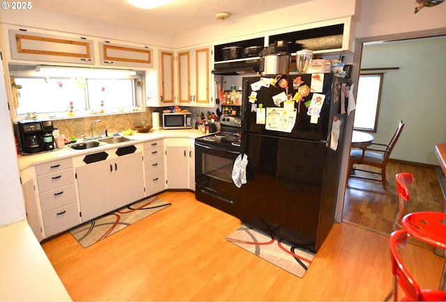 46083 Adams Rd, Pendleton, OR 97801 - kitchen with black appliances, a sink, light countertops, light wood-type flooring, and under cabinet range hood