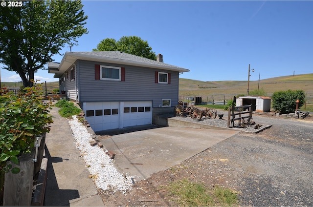 46083 Adams Rd, Pendleton, OR 97801 - view of home's exterior with concrete driveway, a garage, and a chimney
